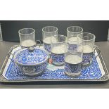 An enamel tea set to include tray, six glass cups with holders a s sugar bowl