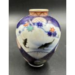 A small Japanese vase in baluster form. Blue grounds and decorated with flowers and fish Height