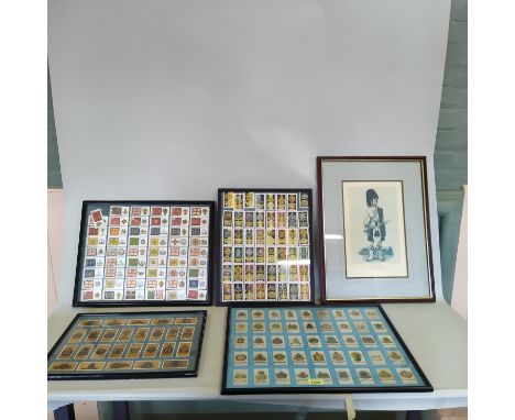 Four framed displays of military themed cigarette cards, including 'silks' territorial badges together with a military print,