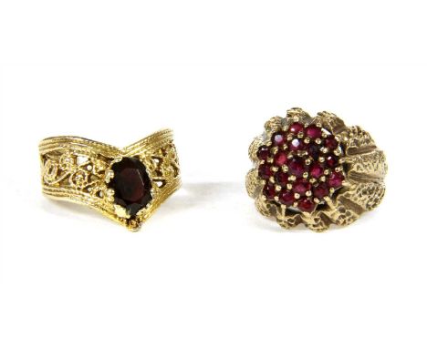 A gold ruby bombé ring, with a tiered three row cluster of round cut rubies, claw set to a textured fluted bombé head and pla