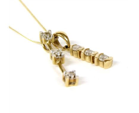 A gold three stone diamond pendant, with a row of three brilliant cut diamonds, bar set to an articulated 'V' bale, tested as