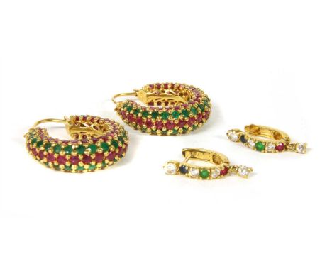 A pair of gold ruby and emerald hoop earrings, with a central row of graduated round cut rubies, with a row of round cut emer