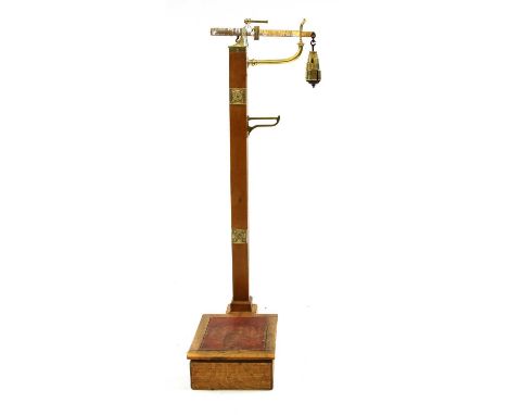 A set of Avery scales, with polished brass weights, 1,2,4,8 and 16 stone, on an oak stand, rexine platform, 133cm high