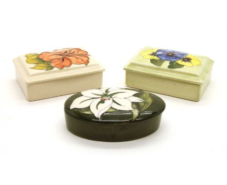 A collection of three various Moorcroft lidded trinket boxes , two rectangular, one oval (3)