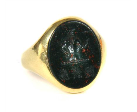 An 18ct gold oval bloodstone signet ring, the bloodstone with intaglio carved crest and initials rub set to tapering shoulder