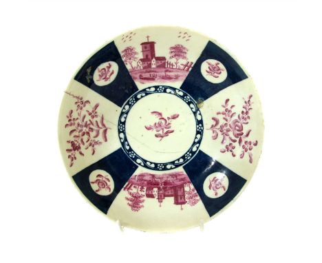 An 18th century Worcester porcelain dish, decorated in puce with church buildings, separated by blue border, under glaze mark