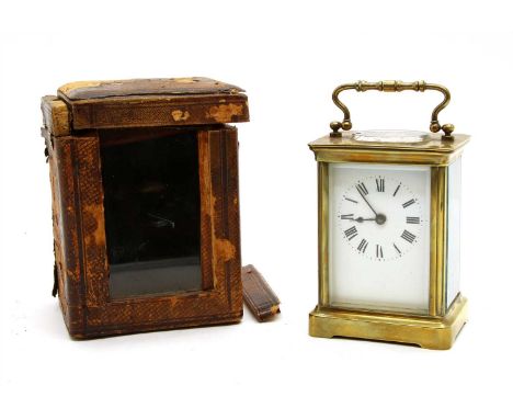A brass carriage clock, having white enamel and black Roman numeral dial, fitted in red leather case, 15cm high