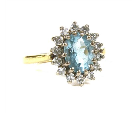 An 18ct gold aquamarine and diamond oval cluster ring, with an oval mixed cut aquamarine claw set to the centre, to surround 