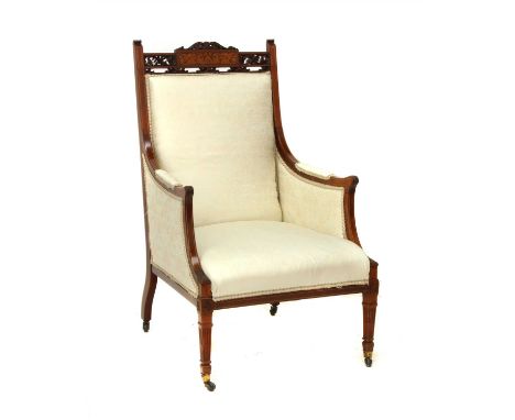 An Edwardian inlaid mahogany armchair , the shaped top rail with pierced and carved floral motifs, the central panel with fin