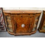 A GOOD VICTORIAN FIGURED WALNUT CREDENZA, the central panelled door inset with a porcelain