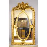 A LARGE LOUIS XVI STYLE GILTWOOD MIRROR, the top with cupids and oval panel. 5ft 10ins high x 3ft