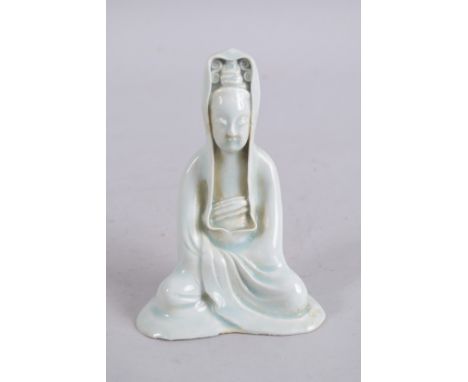 A CHINESE CELADON GLAZE POTTERY FIGURE of seated Guanyin. 15cm high.