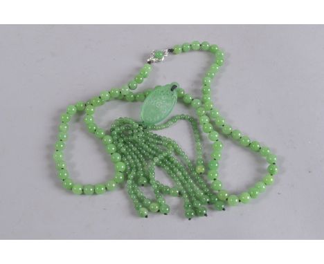 A GOOD STRING OF JADE BEADS with tassel and white gold clasp.