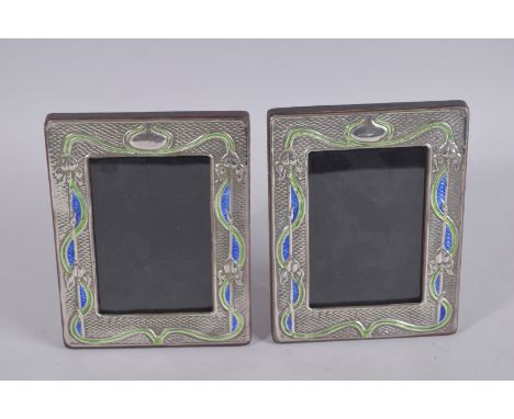 A PAIR OF SILVER AND ENAMEL PHOTOGRAPH FRAMES. 7.5ins x 5.5ins.