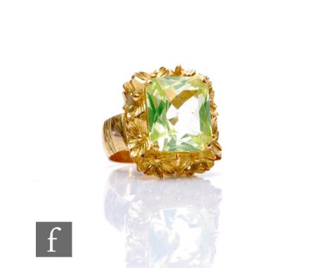 An 18ct hallmarked lemon quartz single stone ring, emerald cut claw set stone to a floral border and wide shank, weight 10.5g