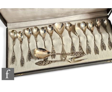 A cased set of twelve continental white metal ornate teaspoons with a matched spoon and fork, total weight 5oz. 