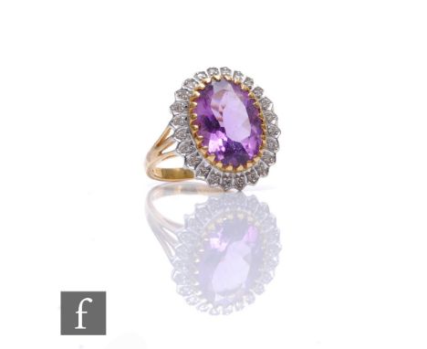 A 9ct hallmarked amethyst and diamond cluster ring, central amethyst within a border of diamonds, weight 4.5g, ring size R. 