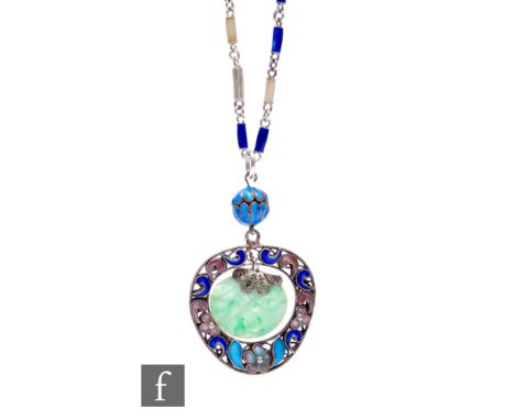 An early 20th Century low grade silver and floral enamelled decorated pendant with central carved jade panel suspended from a