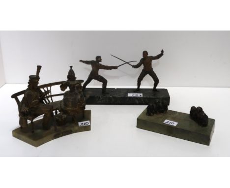 A spelter figure group of two men fencing, together with a see no evil, speak no evil, hear no evil paperweight and a spelter
