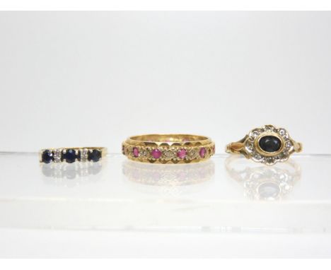 A 9ct gold ruby and diamond full eternity ring, size W1/2, a 9ct sapphire and diamond cluster, finger size P, and a sapphire 