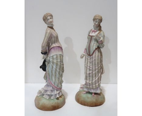 A pair of bisque figures of ladies in Victorian dress with diamond registration mark for 1879 Condition Report:Available upon