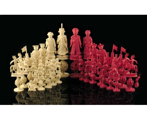 λ A late 19th century Chinese Canton carved ivory figural part chess set, with puzzle ball bases, natural and stained red, th