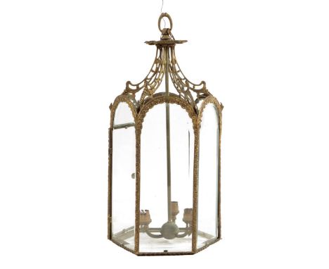 A late Victorian gilt brass hexagonal hall lantern, with bevelled glass panels, a hinged door and a three light fitting, 61.3