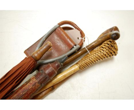 An early 20th century ladies parasol together with one other, various walking sticks, and a shooting stick