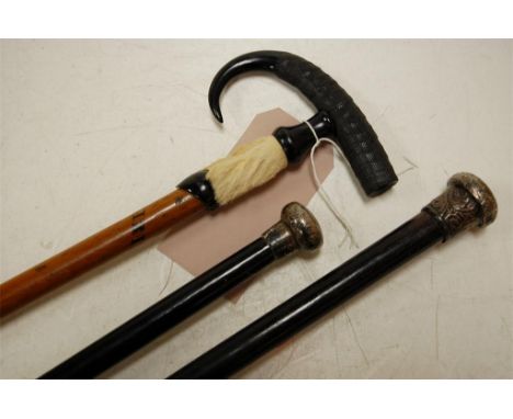 Two early 20th century walking sticks each having an ebony shaft with a silver mount together with another continental walkin