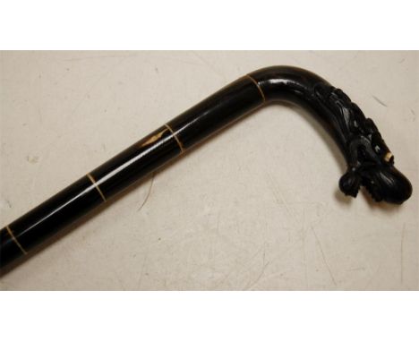 An early 20th century bone and horn walking cane, the handle carved as a dragon's head