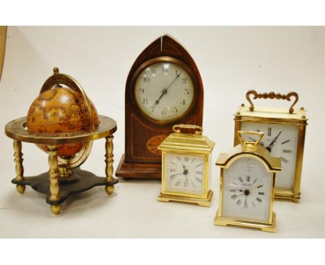 An Edwardian inlaid mahogany lancet top mantel clock, three reproduction brass cased carriage clocks, and a reproduction terr
