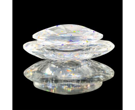 A clear crystal trinket box that is round in shape with a dip in the center and a round clear lid that has different texture 