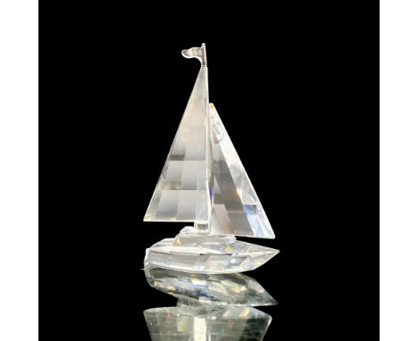 A clear crystal figure of a sailboat with an open mast with a flag at the top. Swarovski backstamp. This item has its origina