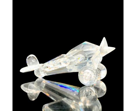 A clear crystal figure of an old-fashioned airplane that has a front propeller. Swarovski backstamp. This item has its origin