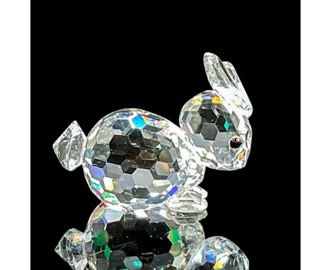 Clear faceted crystal figure of a little rabbit with black eyes lying down. Swarovski mark. Item number 7678NR030. Part of th