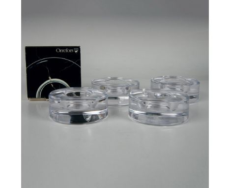 A sleek set of 4 round clear candle holders, designed in the shape of pucks with a center hole for easy candle placement. Mar