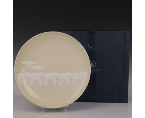 This gorgeous large round wall art platter is finished in a glossy ivory color, showcasing a family of elephants depicted in 