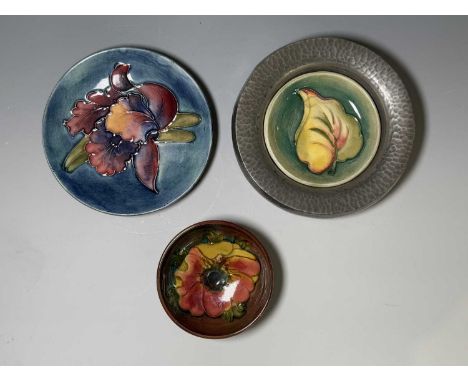 Three pieces of Moorcroft, to include a small flambé bowl, a pin dish and another in a Tudric setting (4)