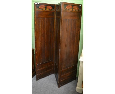 An Edwardian Arts and Crafts stained oak three-fold screen by Liberty & Co, inset with incised and stained panels of stylized