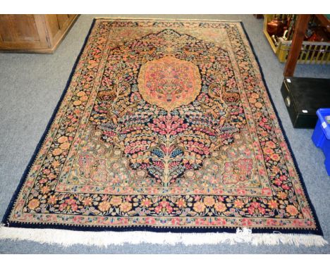Kirman rug, South East Iran, the indigo field with a candy pink panel enclosed by meandering vine borders, 234 by 150cm