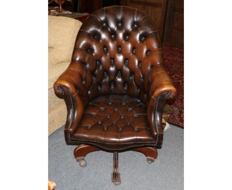 A reproduction button brown leather swivelling office chair