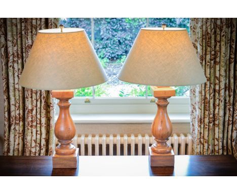 A pair of turned walnut table lamps, of baluster form, 48cm high excluding fitments, 81cm high including shade, together with