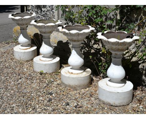 A set of four cast iron garden urns, in the manner of examples by Andrew Handyside and co. of Derby, late 19th century, with 