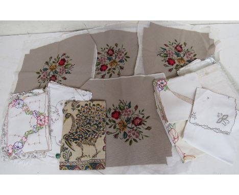 A crate containing four tapestry seat covers and a selection of embroidered table linens 