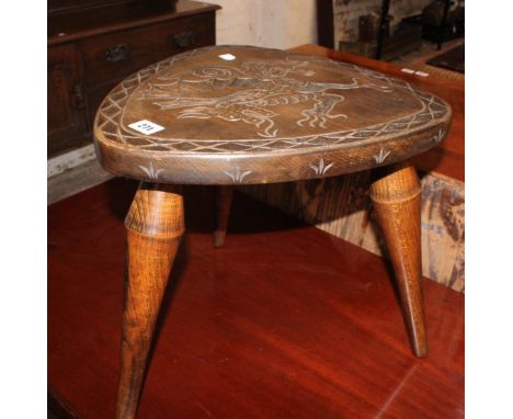 A pair of beech carved back stools and a stool decorated with dragons and armorials 