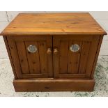 A pine side cabinet opening to shelves and cut out back (H58cm W68cm D43cm)