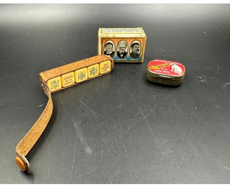 A selection of curios to include a WWII commemorative match box cover, a vintage HMV record needle tin and poker disc