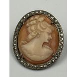 A vintage cameo on silver brooch with lady in classical in pose.