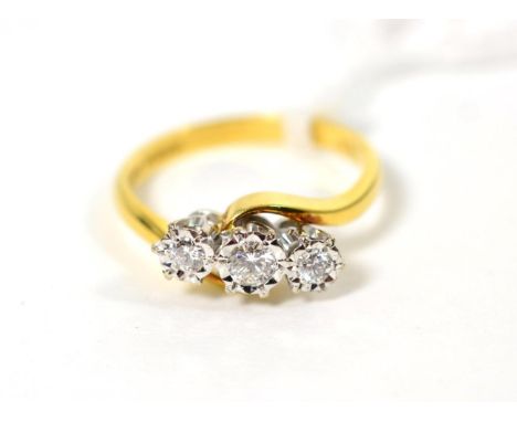 An 18 carat gold diamond three stone ring, graduated round brilliant cut diamonds in illusion settings, to bypass scroll shou