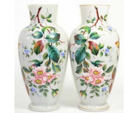 A pair of Victorian enamel painted opaque glass vases decorated with butterflies and flowers 